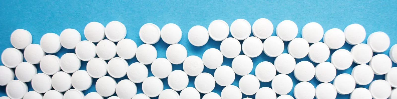 White tablets scattered on a blue background