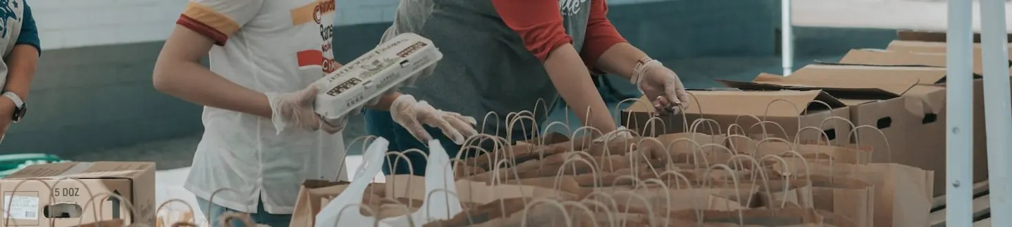 Volunteers packing food into paper bags